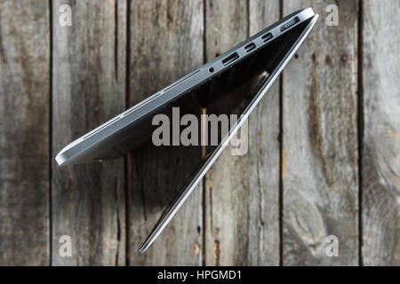 laptop standing on side on wooden table Stock Photo