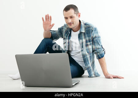 Young man talking to each other via online video chat. Handsome man using a laptop for business and entertainment Stock Photo