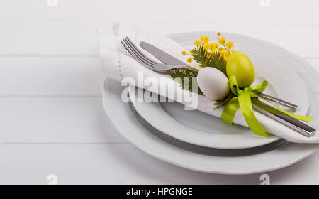 Easter dinner table setting on white wooden table, festive holiday background top view Stock Photo