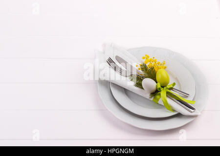 Easter dinner table setting on white wooden table, festive holiday background top view Stock Photo