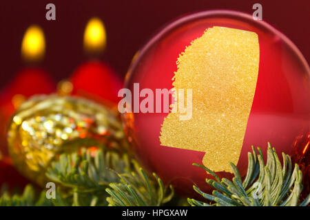 A glossy red bauble with the golden shape of Mississippi.(series) Stock Photo