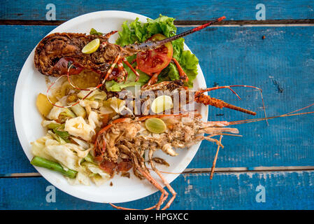 Tasty lobsters and jumbo prawns prepared with garlic and lime on tropical background Stock Photo