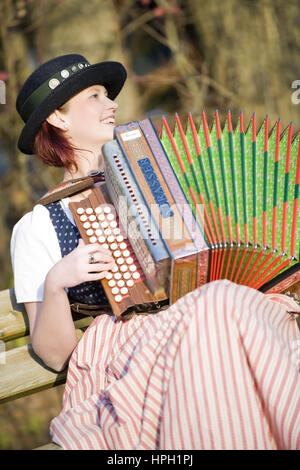 Model released , Junge Frau in Tracht mit Steirischer Harmonika - woman in traditional costume with Styrian Harmonica Stock Photo