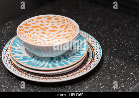 cap and Dishes stacked on shelves in a kitchen area. Stock Photo