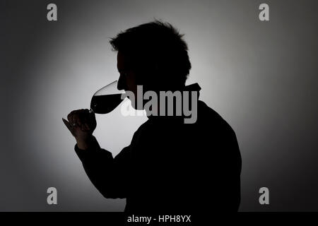 Mann trinkt aus Weinglas, Silhouette - man drinks wine, Model released Stock Photo