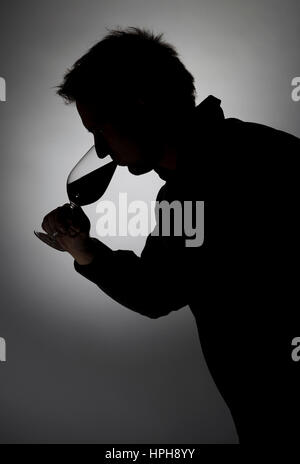 Mann trinkt aus Weinglas, Silhouette - man drinks wine, Model released Stock Photo