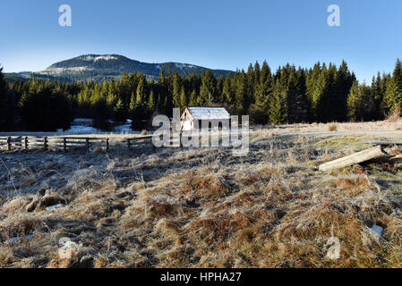 Wooden cottage in the mountains in a cold winter morning Stock Photo