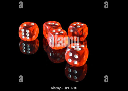 Five transparent red dice on black surface with reflection. Stock Photo