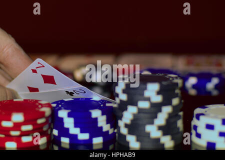 Bluffing in Texas hold'em. Poker player has very bad pocket cards. Stock Photo