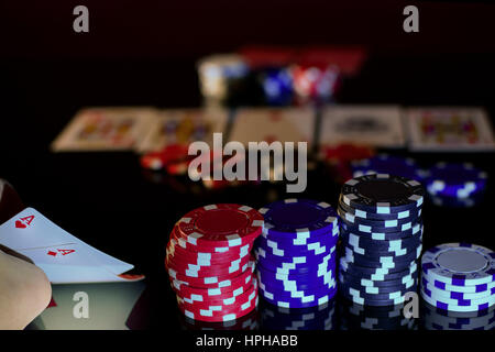 Pair of aces in pocket pair and poker chips. Black surface, horizontal view. Stock Photo