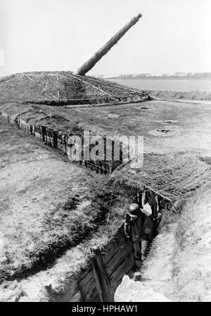 The Nazi propaganda image shows a German Wehrmacht soldier in a communications trench on the French channel coast. Published in July 1943. A Nazi reporter has written on the reverse, 'Heavy artillery on the channel coast. Communication trenches link gun stations up with one another.' Fotoarchiv für Zeitgeschichte - NO WIRELESS SERVICE - | usage worldwide Stock Photo