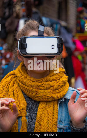 New and innovative Virtual Reality headset being tested by a young woman on the streets of London at Camden Market Stock Photo