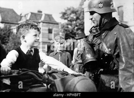 The Nazi propaganda image shows a local boy on a motorcycle next to a German Wehrmacht soldier in the occupied Netherlands. Taken in May 1940. A Nazi reporter has written on the reverse of the picture on 25.05.1940, 'Trusting Dutch boys. The German dispatch rider lets the young, intrigued Dutch boy sit on his  motorbike once. The little boy is visibly delighted.' Fotoarchiv für Zeitgeschichte - NOT FOR WIRE SERVICE - | usage worldwide Stock Photo