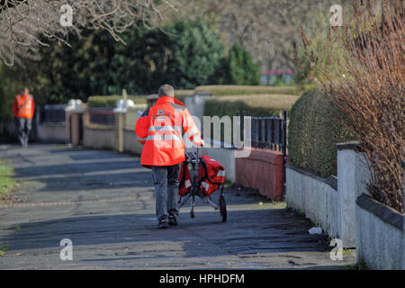 Royal Mail postman delivering letters with trolly Stock Photo