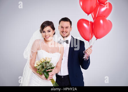 Bride with roses and groom with balloons Stock Photo