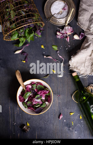 Salad with fresh summer greens and herbs on rustic wooden table. View from above, free text space. Stock Photo