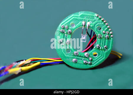 Close up of small circular printed circuit board, PCB with wires. Stock Photo