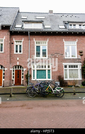 Bicycles parked on the street outside a typical row of Dutch houses. Stock Photo