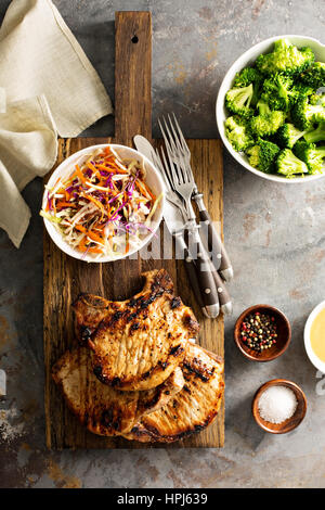 Grilled pork chops with cole slaw salad and steamed broccoli Stock Photo