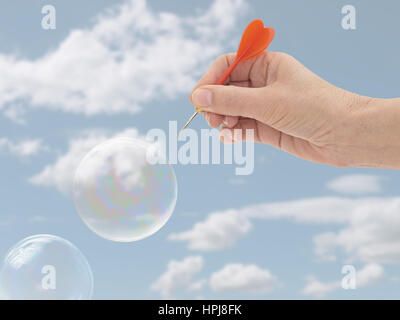Burst the bubble concept. Financial, business or general concept, metaphor. Woman's hand. Stock Photo