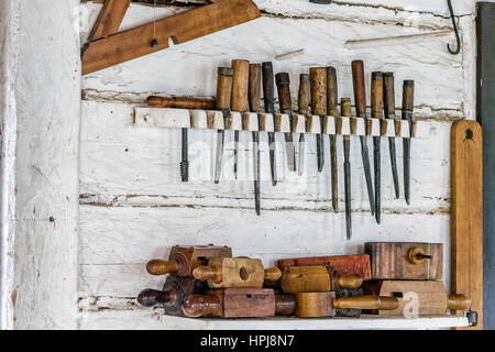 Vintage carpentry tools hanging on wall. Stock Photo