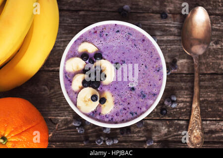 Tasty and healthy milkshake smoothie made from banana and blueberries on rustic wood Stock Photo