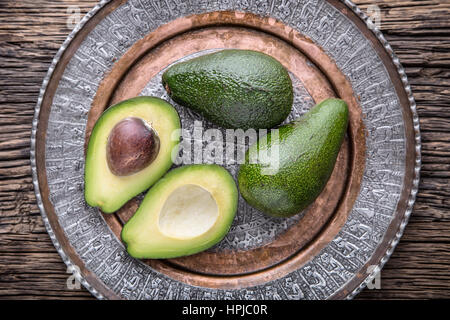 Avocado. Cut avocado on a oak wood background table. Selective focus. Stock Photo