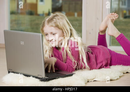 Model released , Maedchen, 8,  mit Laptop am Fussboden - girl using laptop