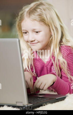 Model released , Maedchen, 8,  mit Laptop am Fussboden - girl using laptop