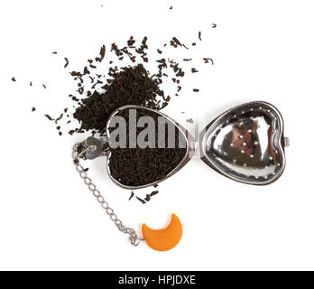 Putting black tea in the tea strainer. Isolated on white Stock Photo