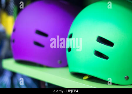 Inline and quad roller skates helmets head protection in retail skate shop display on sale. Stock Photo