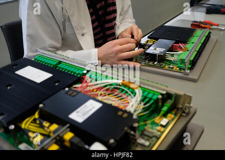 Worker assembling an electronic device at a factory Stock Photo