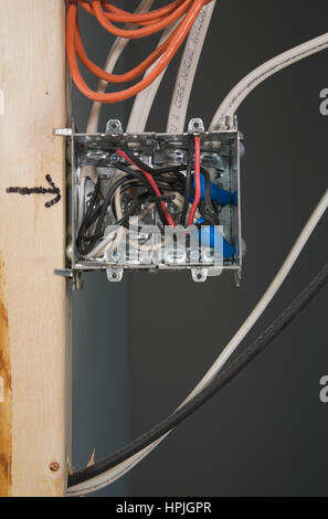 Electrical wall outlet box mounted on wall stud inside a home. Stock Photo