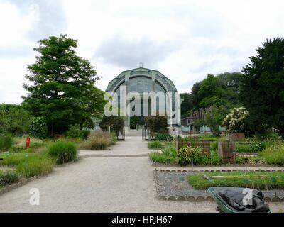 View of large greenhouse for tropical plants down a long garden path. Jardin des Plantes, Paris, France. Stock Photo