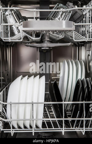 Clean glasses and plates after washing in dishwasher machine Stock Photo