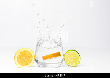 Kiwi in the glass of water, piece of lemon and lime Stock Photo