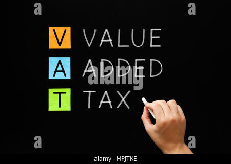 Hand writing VAT - Value Added Tax with white chalk on blackboard. Stock Photo
