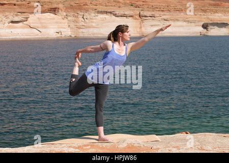 woman practicing yoga by lake Stock Photo