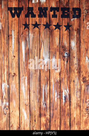 Wanted word in western style on brown wood backgrond Stock Photo