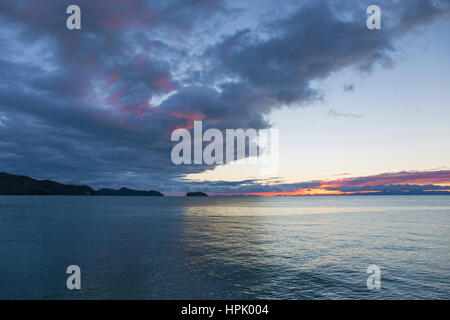 Marahau, Tasman, New Zealand. View across Tasman Bay to the coastline and offshore islands of Abel Tasman National Park, dawn. Stock Photo