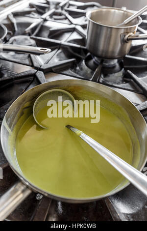 Light summer green pea cream soup prepared in restaurant kitchen Stock Photo