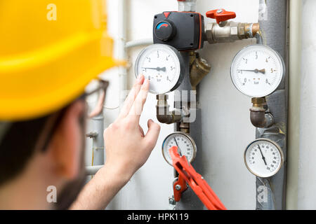 maintenance - technician checking pressure meters for house heating system Stock Photo