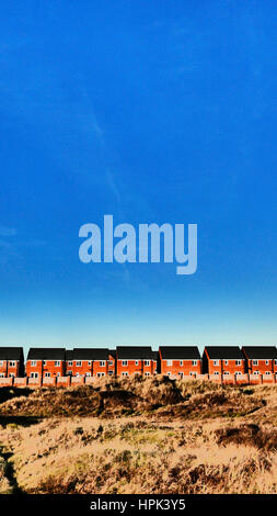 Row of new detached houses against blue sky Stock Photo