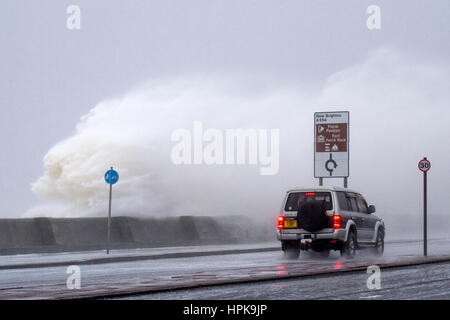 Storm Doris, New Brighton, Cheshire, UK. 23rd Feb 2017. Storm force winds and high stide batter  the Wirral Peninsula as she made land this morning.  Drivers had to be extra careful as winds gusting up to 80mph swept the 26' tidal surge onto the promenade as people made their way to work. Stock Photo