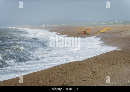 Chesil Beach, Portland, Dorset, UK. 23rd February, 2017. Storm Doris hits Portland as the Enviroment agency with four large diggers repairs Chesil Beach shingle banks during low tide. © Dan Tucker/Alamy Live News Stock Photo