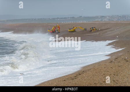 Chesil Beach, Portland, Dorset, UK. 23rd February, 2017. Storm Doris hits Portland as the Enviroment agency with four large diggers repairs Chesil Beach shingle banks during low tide. © Dan Tucker/Alamy Live News Stock Photo