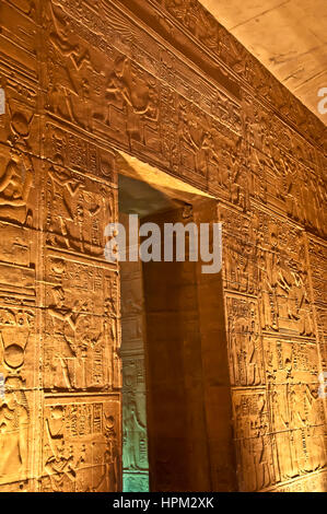 Illuminated wall covered with hieroglyphs inside Philae Temple, no people Stock Photo