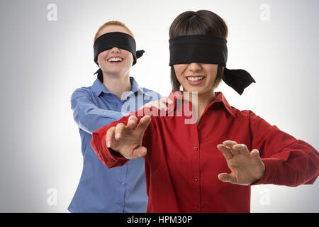 two business woman blind folded leading the other Stock Photo