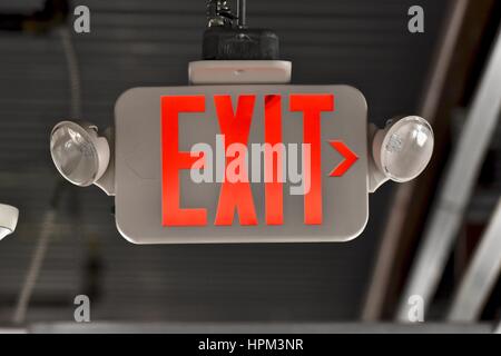Emergency exit sign in hallway of building Stock Photo