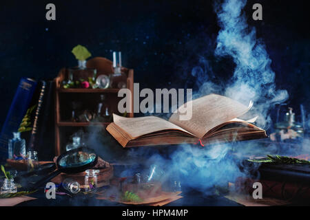 Still life with levitating book of spells, jars and bottles on a dark background with rising mystic smoke
